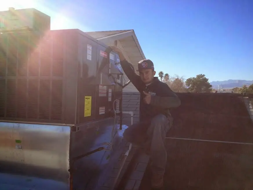 HVAC technician performing AC Tune-Up on a rooftop unit in DuBois